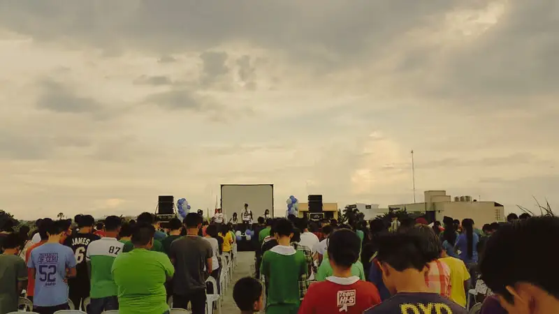 A large outdoor youth gathering at sunset